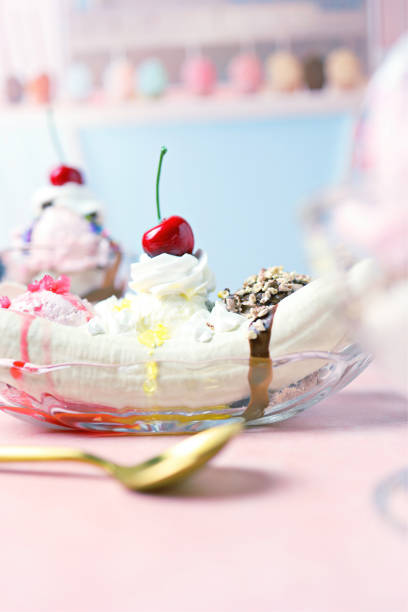 Banana split decorated with cherries on a colorful background. Copy space.