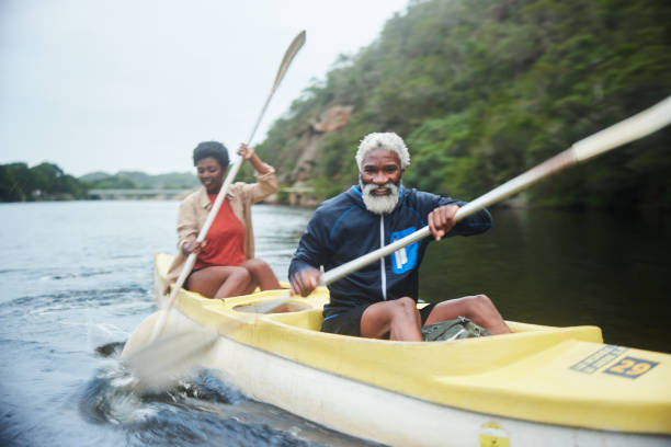 istock Smiling mature couple paddling a double canoe on a scenic river 1459602981