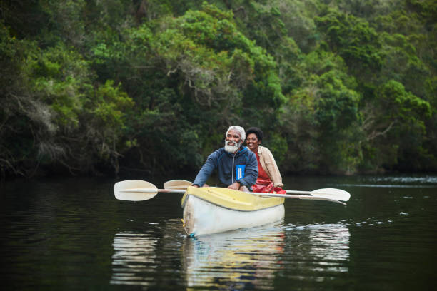 istock Smiling mature couple floating in a double canoe down a scenic river 1459603070