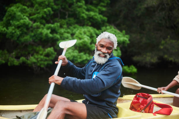 istock Smiling man paddling a double canoe with his wife on a river 1459603148