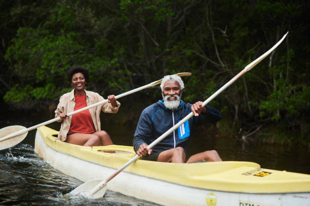 istock Smiling couple paddling a double canoe together down a river 1459603325
