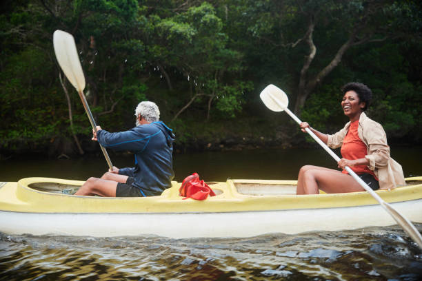 istock Smiling couple paddling a double canoe together along a river 1459603504