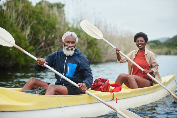 istock Smiling couple paddling a double canoe together along a river 1459603583