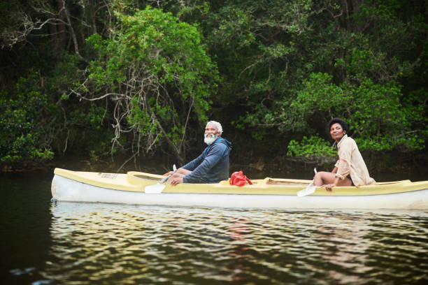 istock Smiling couple floating in a double canoe together on a river 1459604896