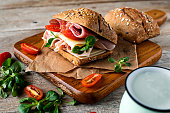 A delicious sandwich with ham, prosciutto, cheese and vegetables