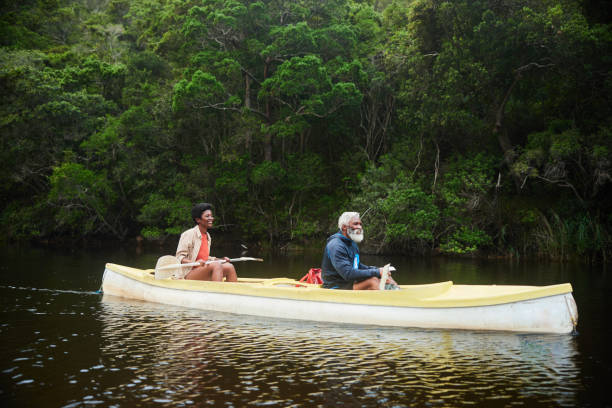 istock Smiling couple floating in a double canoe together down a river 1459605147