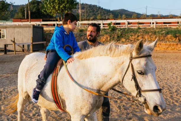 istock Physiotherapist using a horse as therapy for a child with cerebral palsy 1459606933