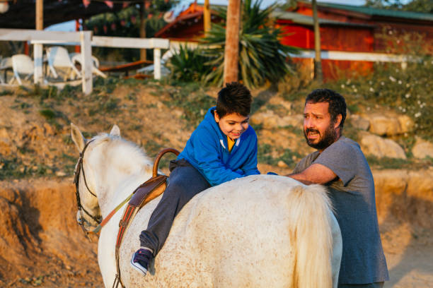 istock Physiotherapist during an equine therapy session with a child with disability 1459607289