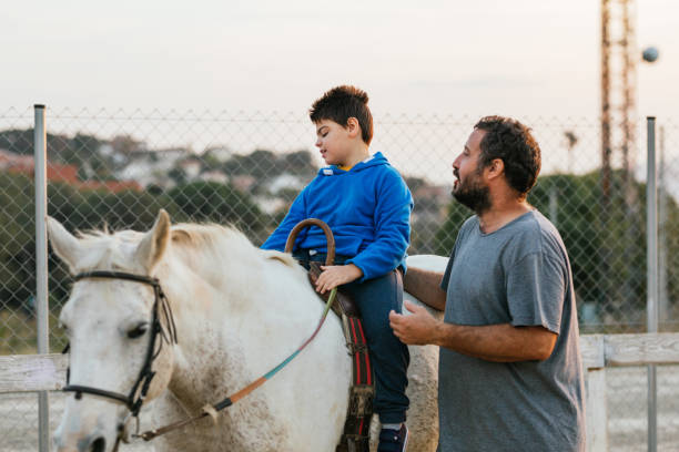 istock Boy with cerebral palsy riding a horse next to instructor 1459608186
