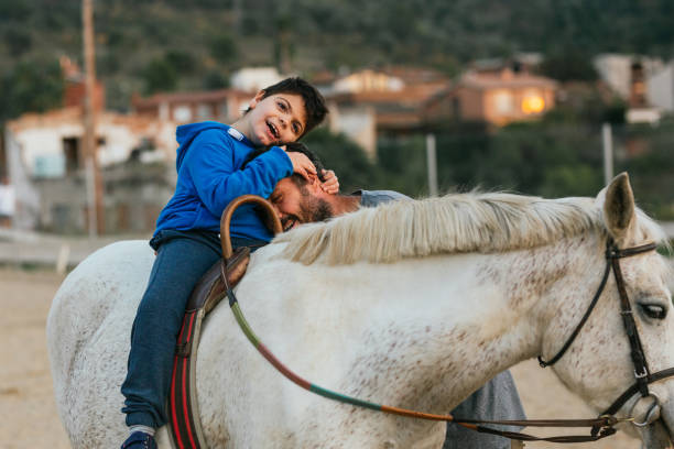 boy with disability hugging his physiotherapist during equine therapy session