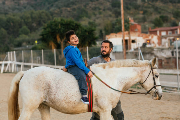istock Happy boy with disability having fun during equine therapy 1459608702