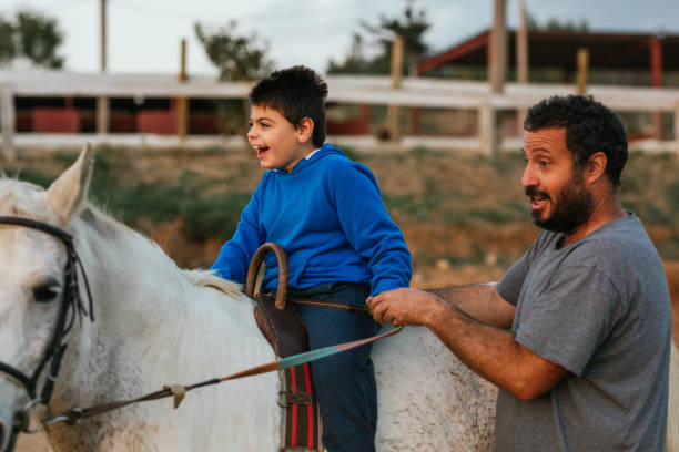 istock Happy boy with cerebral palsy on a horse 1459609014