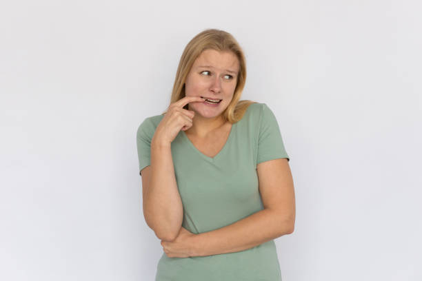 istock Worried young woman biting nail 1459609181