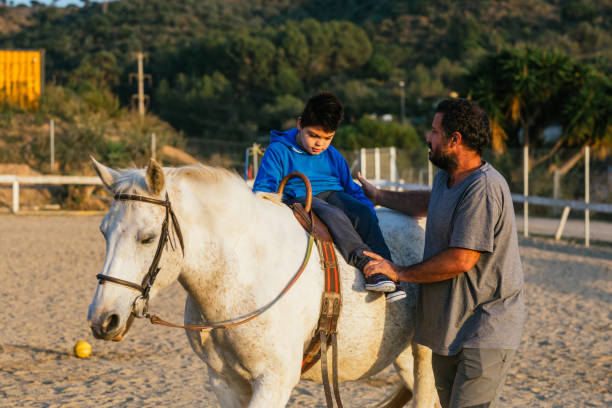 istock Child performing rehabilitation exercises during equine therapy 1459609596