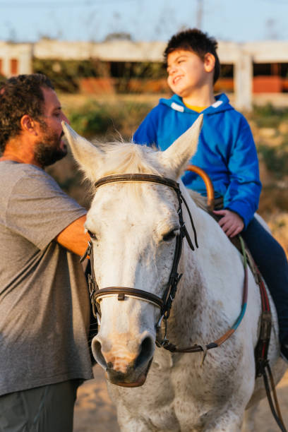 istock Smiley young man with cerebral palsy receiving equine therapy 1459609780
