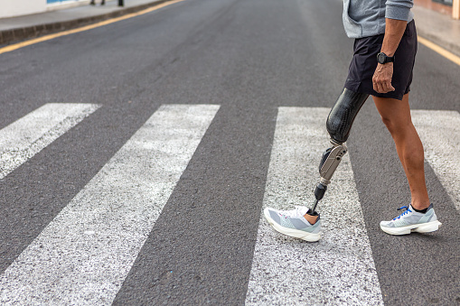 Atleta masculino discapacitado cruzando la carretera photo