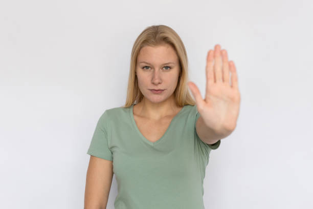istock Serious young woman showing stop sign 1459610394