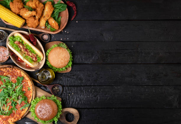 istock Assorted take out or delivery foods, above view side border on a dark wood background 1459615855
