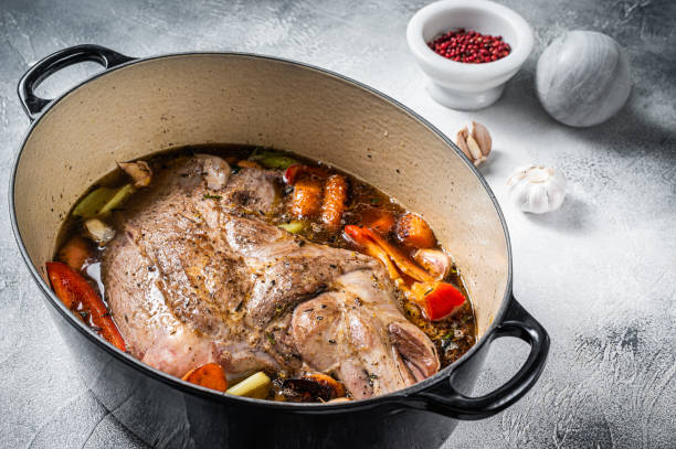 istock Braised lamb mutton shoulder in a baking dish with vegetables in red wine. White background. Top view 1459617246