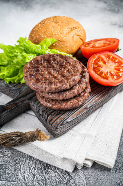 istock Fried cutlet for burger with vegetables and spices on wooden board. White background. Top view 1459617546