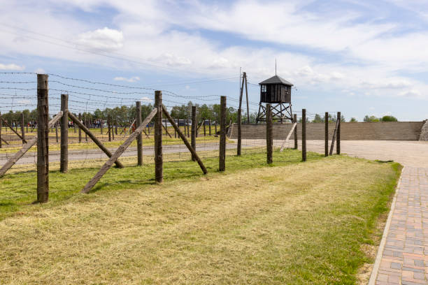 Majdanek; Lublin; Poland - May 25, 2022: Majdanek concentration and extermination camp ( Konzentrationslager Lublin), view on barbed wire fence and guard tower. It was a Nazi camp built and operated by the SS during the German occupation of Poland in World War II