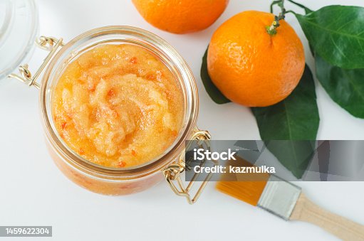 istock Orange clementine fruit mask (scrub) in a glass jar. Homemade face or body mask, natural beauty treatment and spa recipe. Top view. 1459622304