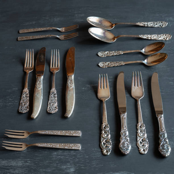 istock A collection of tarnished silverware laid out on a dark background. 1459627957