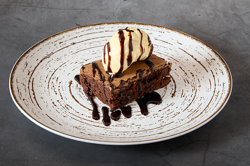 plate with a chocolate brownie and vanilla ice cream