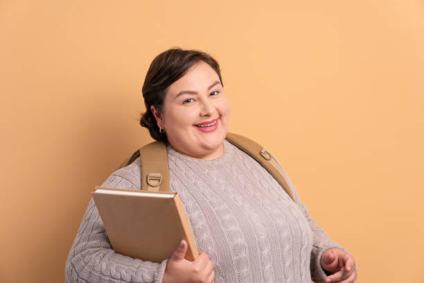 istock student holding academy book and smiling 1459631024