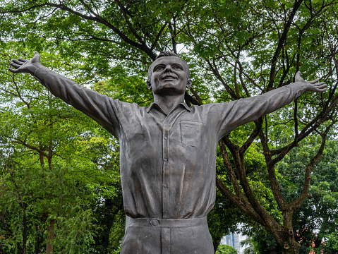 Jakarta, Indonesia - August 16, 2022: A statue of Soviet cosmonaut, Yuri Alekseyevich Gagarin, at a city park under shady trees on a sunny morning.