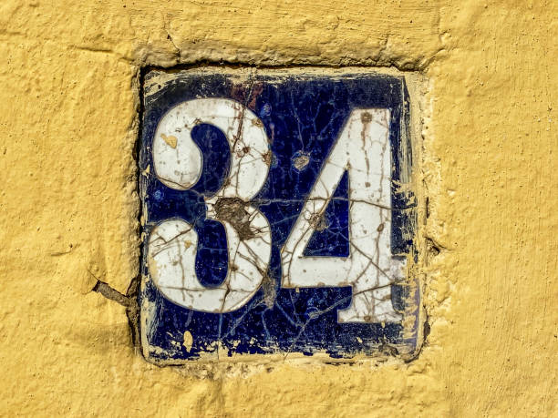 istock Tile with the number 34 in yellow wall 1459641158