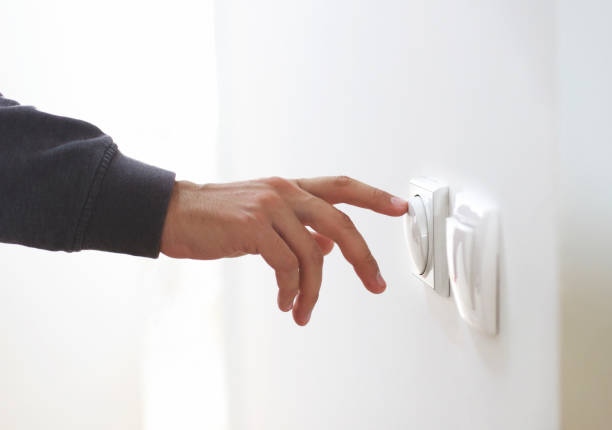 istock Closeup of man's finger turning off on lighting switch to save 1459642910