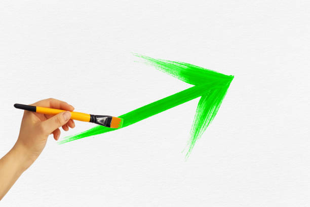 istock Hand drawing an upward green arrow on white paper background 1459646395