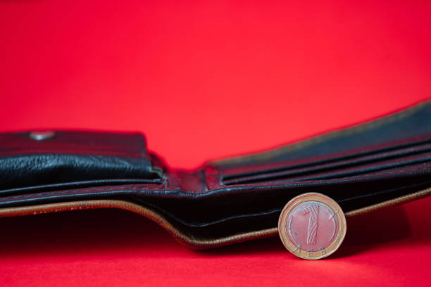 Bulgarian lev coin on red backdrop. Blurred empty wallet in the background. Inflation, money shortage.
