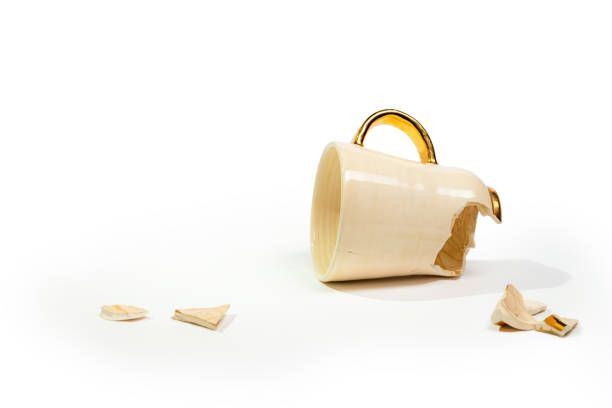 Broken tea cup isolated on white background. Cracked coffee mug and fragile ceramic pieces