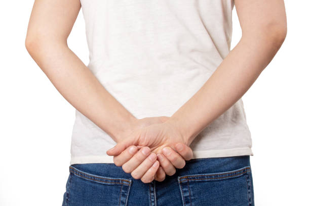 Cropped shot  of a young woman back turned holding hands behind back in blue jeans on white background. Casual style. Cropped shot  of a young woman back turned holding hands behind back in blue jeans on white background. Casual style. hands behind back stock pictures, royalty-free photos & images