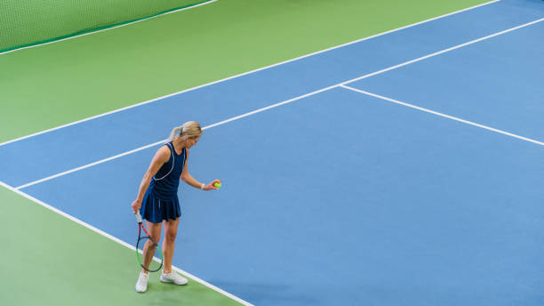 tennista che si prepara a colpire una palla con una racchetta durante la partita di campionato. atleta professionista in procinto di scioperare. torneo sportivo mondiale. foto grandangolare ad alto angolo. - campionato foto e immagini stock