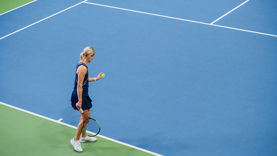 Female Tennis Player Preparing for Hitting a Ball with a Racquet During Championship Match. Professional Woman Athlete About to Strike. World Sports Tournament. High Angle Wide Shot.