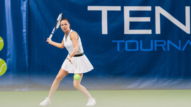 tenista feminina batendo bola com uma raquete durante a partida do campeonato. atleta mulher profissional recebe e prestes a conseguir tiro de backhand perfeito. conceito de torneio mundial de esportes. - forehand - fotografias e filmes do acervo