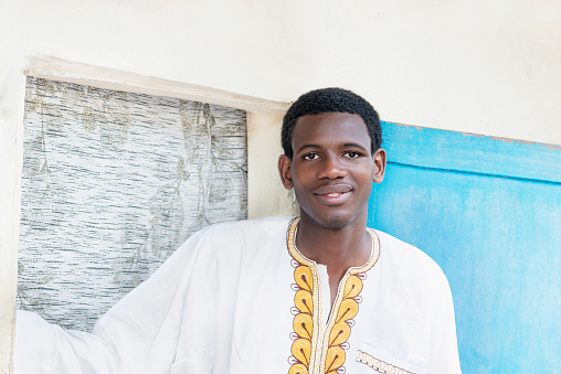 Young man ready for a celebration,  embroidered white and yellow garment, 19 years old, photo