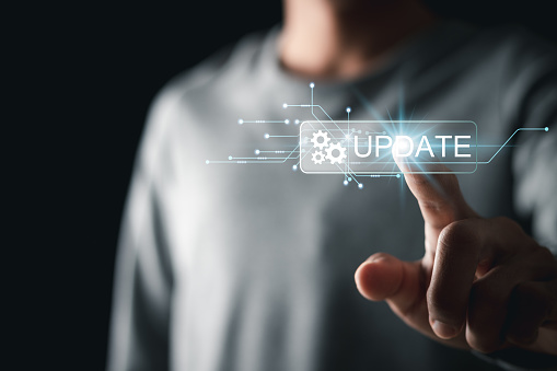 Man touching update button on virtual interface. Software updates or operating system upgrades to keep your device up to date with enhanced functionality in new versions and improved security.