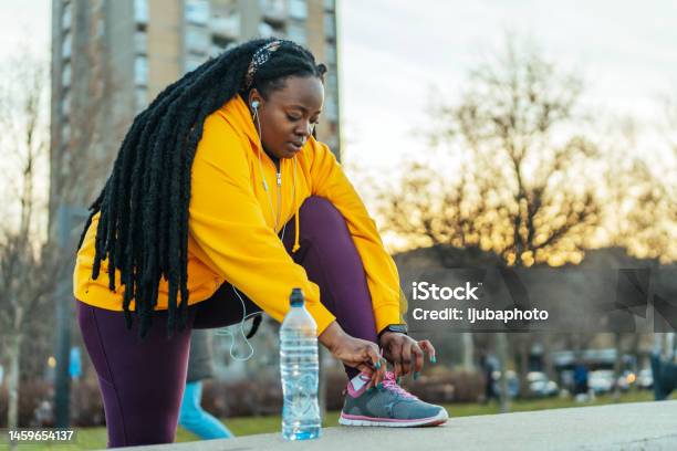 Afroamerican Woman Preparing For A Workout Stock Photo - Download Image Now - Springtime, Only Women, Outdoors