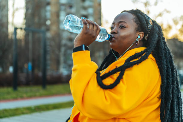 istock Overweight woman drinking water after exercise 1459654286