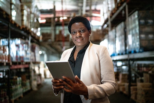 Portrait of a mature woman using the digital tablet in a warehouse