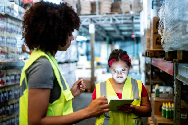 istock Disabled young woman working with coworker in a warehouse 1459659104