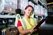 Portrait of a disabled young woman holding a clipboard in a warehouse