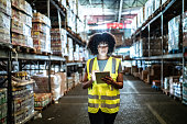 Young woman using the digital tablet in a warehouse