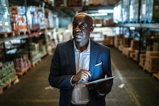 Portrait of a mature man using the digital tablet in a warehouse