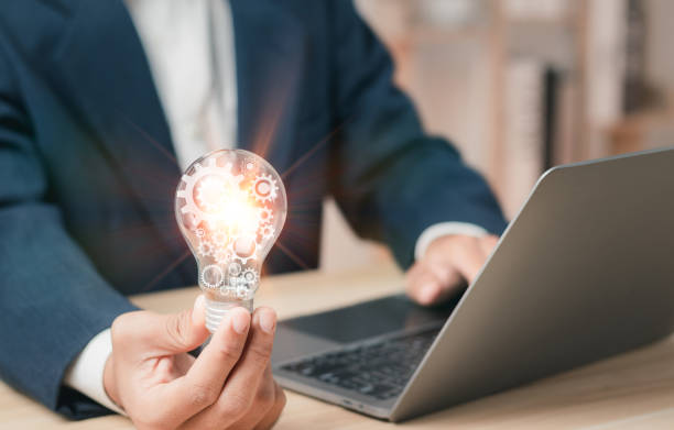 istock Businessman with gears in bright light bulb. Creative ideas and imagination and inspiration with modern innovation. Concept for success. 1459661084