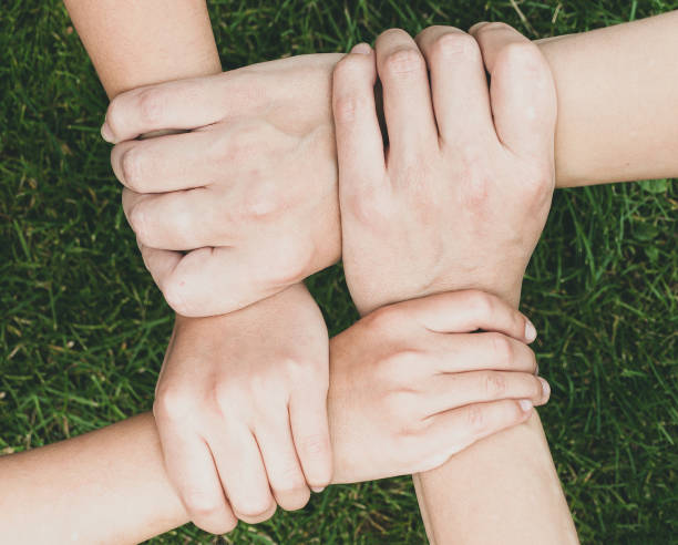 istock crossed hands of family over grass 1459664132